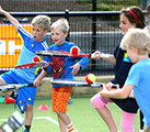 Children playing balance the ball on the tennis racket